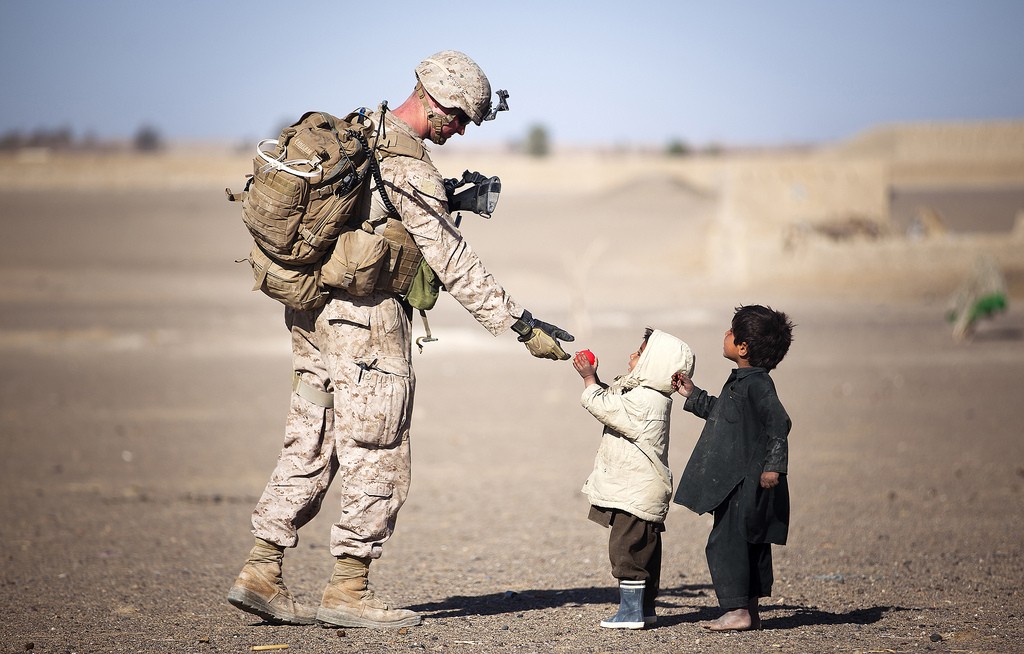 U.S. Marine Lance Cpl. Tom Morton, a 23-year-old team leader with 3rd Platoon, Kilo Company, 3rd Battalion, 3rd Marine Regiment, and native of Nashville, Tenn., hands an Afghan child a toy during a security patrol. (Photo: Flickr)